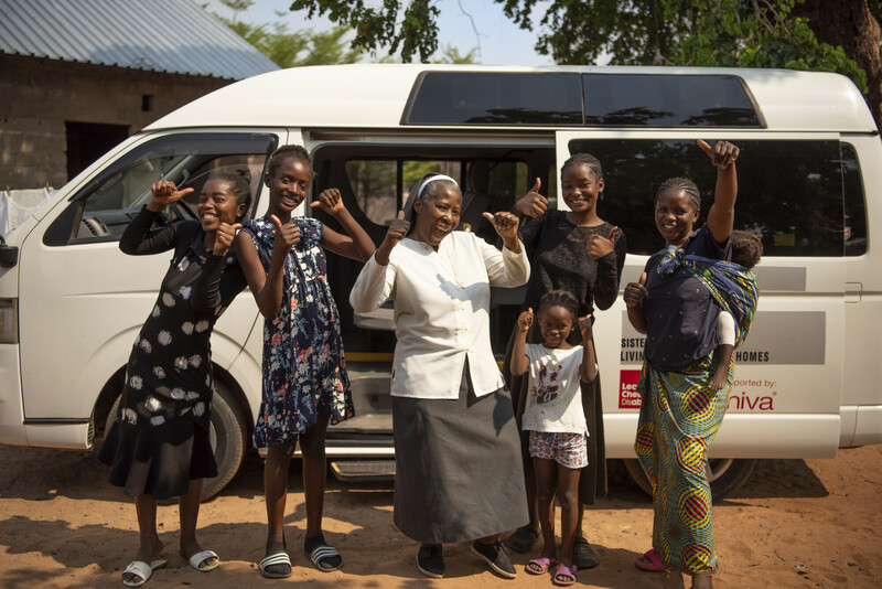Clarina, schoolgaande meisjes en hun ouders zijn blij met de minibus